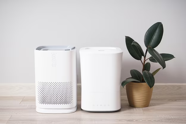Two types of air purifiers with a plant beside them
